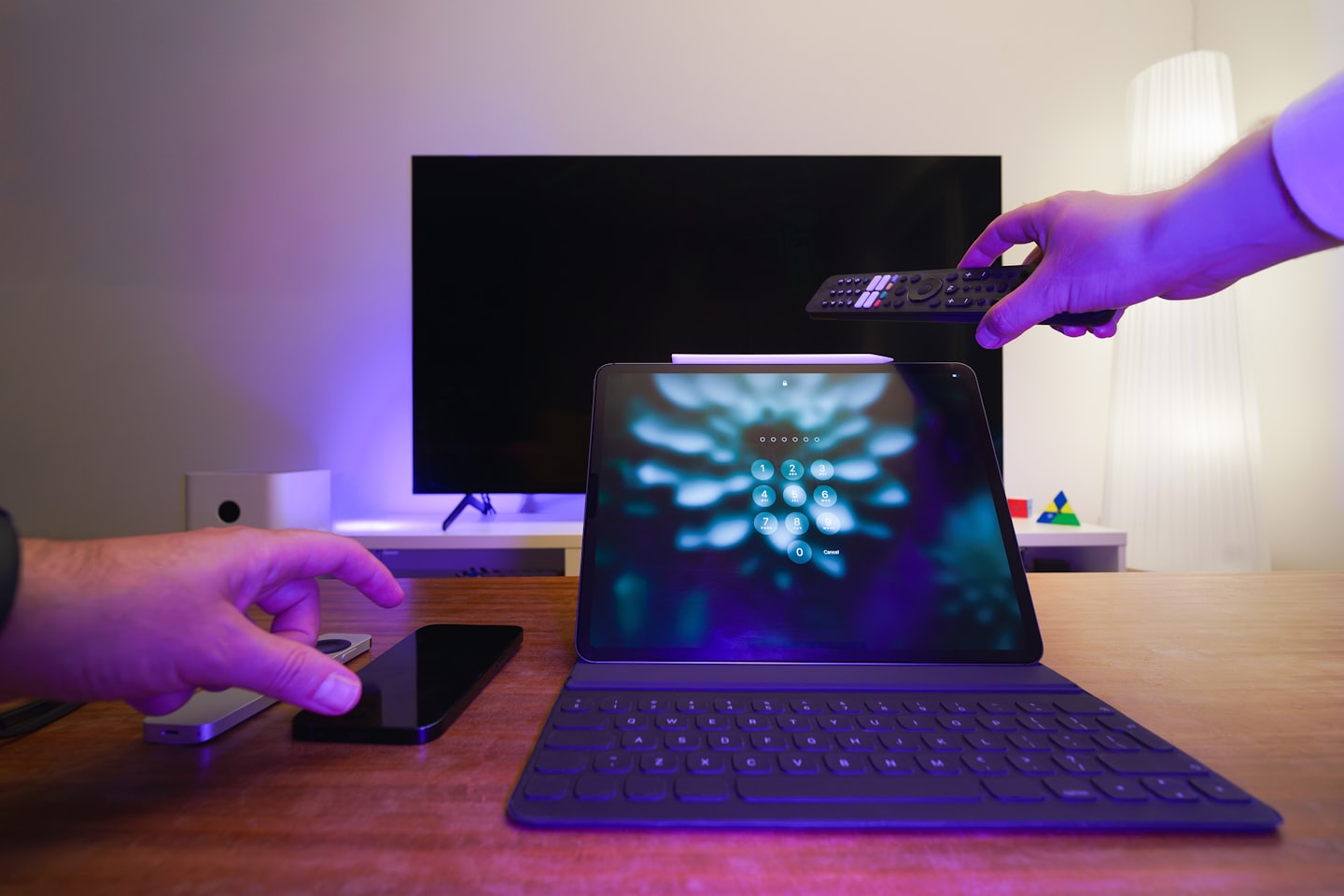 Hände, die auf einem Schreibtisch mit Smart-Home-Technologie interagieren.